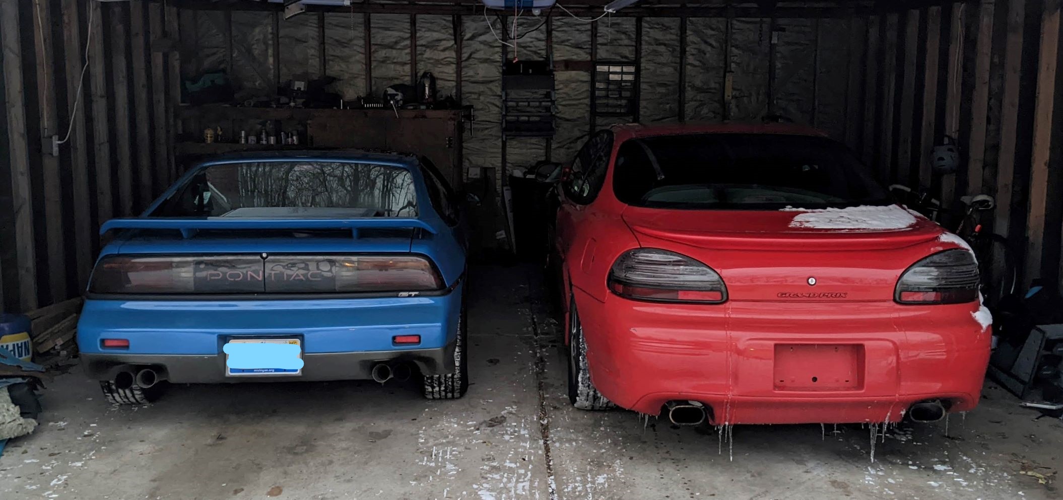 The blue 1987 Fiero sitting to the left of the red 2002 Grand Prix in my garage.